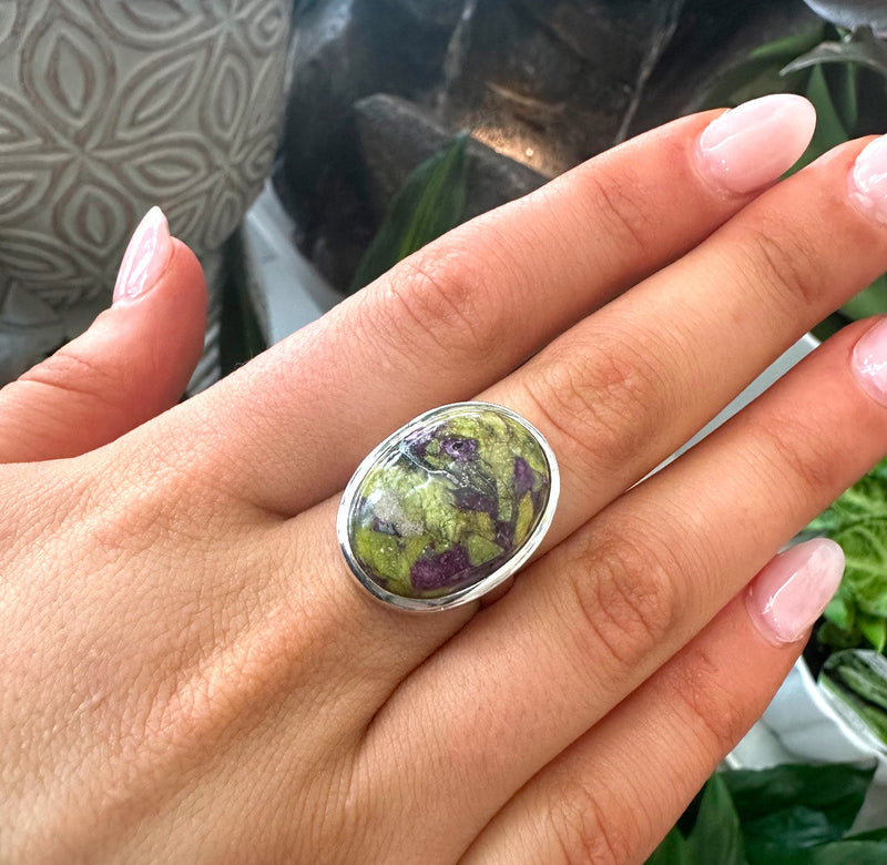 A hand wearing a Tasmanite crystal ring in sterling silver to highlight crystal and gemstone jewellery at My Florist Launceston.