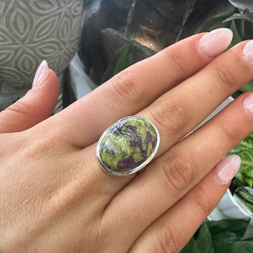 An Alantasite gemstone in a sterling silver ring adorned on a hand to highlight Crystal and Gemstone Rings in Launceston