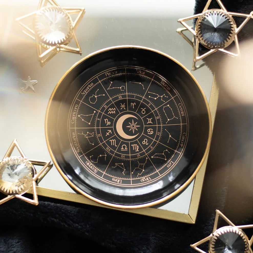 Decorative plate with astrological symbols on a reflective surface