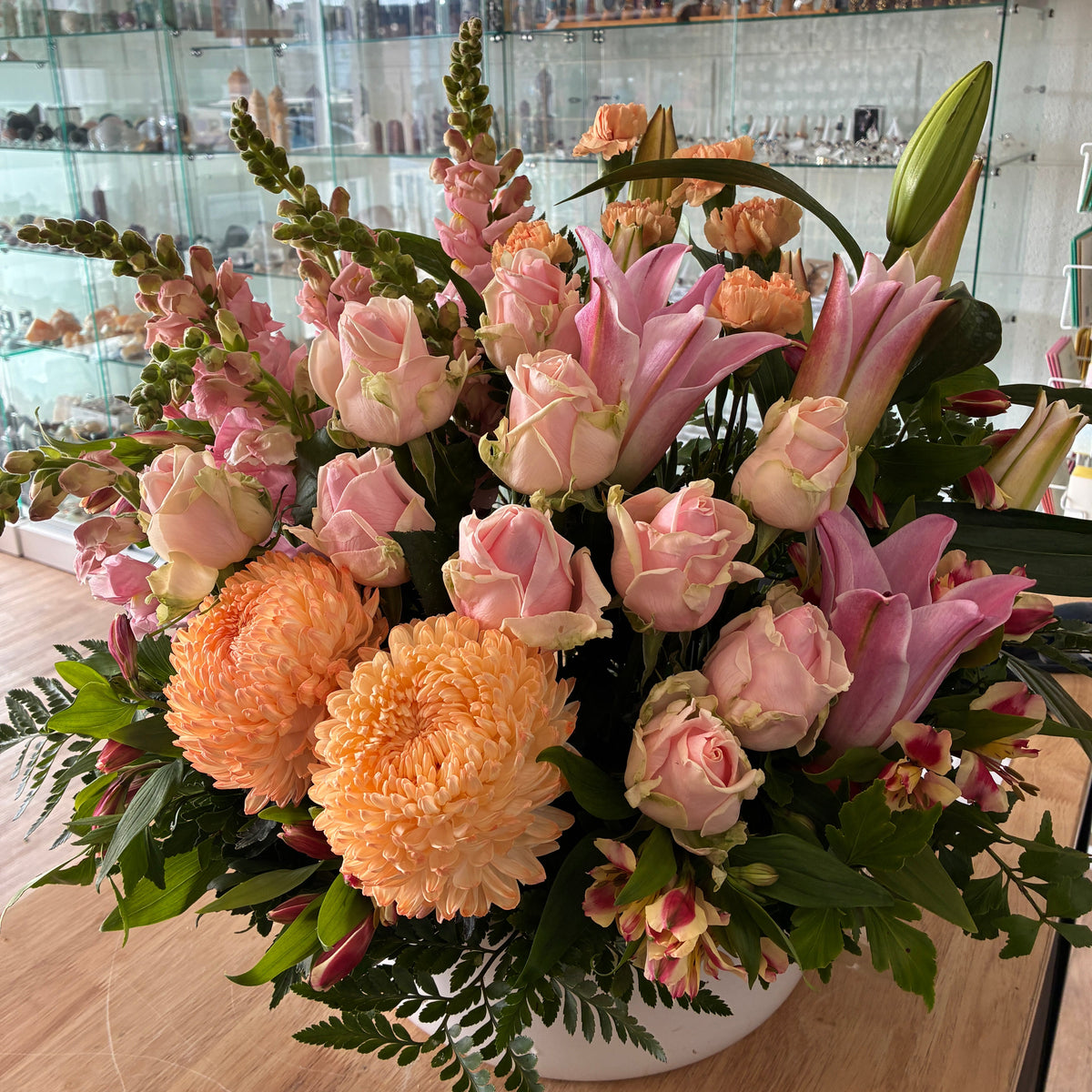 Deluxe pastel ceramic flower arrangement with apricot and pink blooms, ready for flower delivery in Launceston