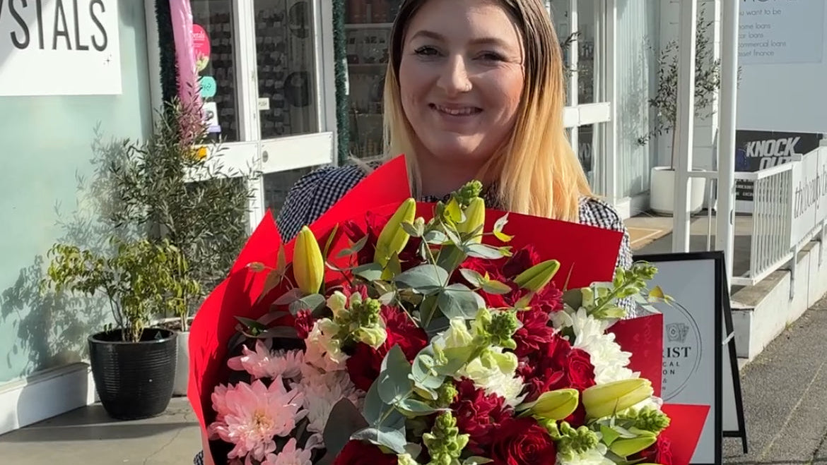 Florist holding a large bouquet of flowers for delivery in front of My Florist Launceston.