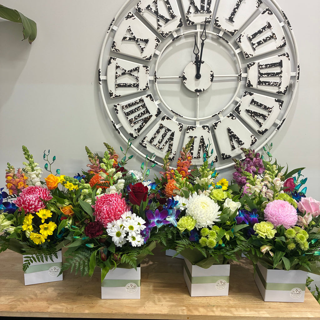 Floral arrangements with mixed assorted coloured blooms.