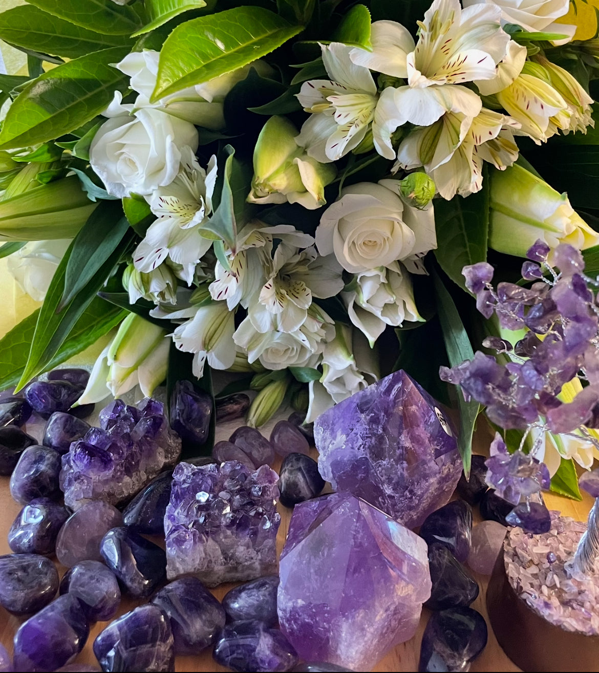White roses, lilies and alstroemeria displayed with various purple amethyst crystals at My Florist Launceston.