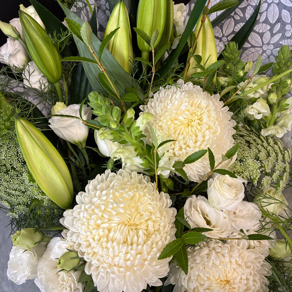 Flat-lying sympathy flower sheaf arrangement custom-crafted for funeral tributes in Launceston Tasmania.