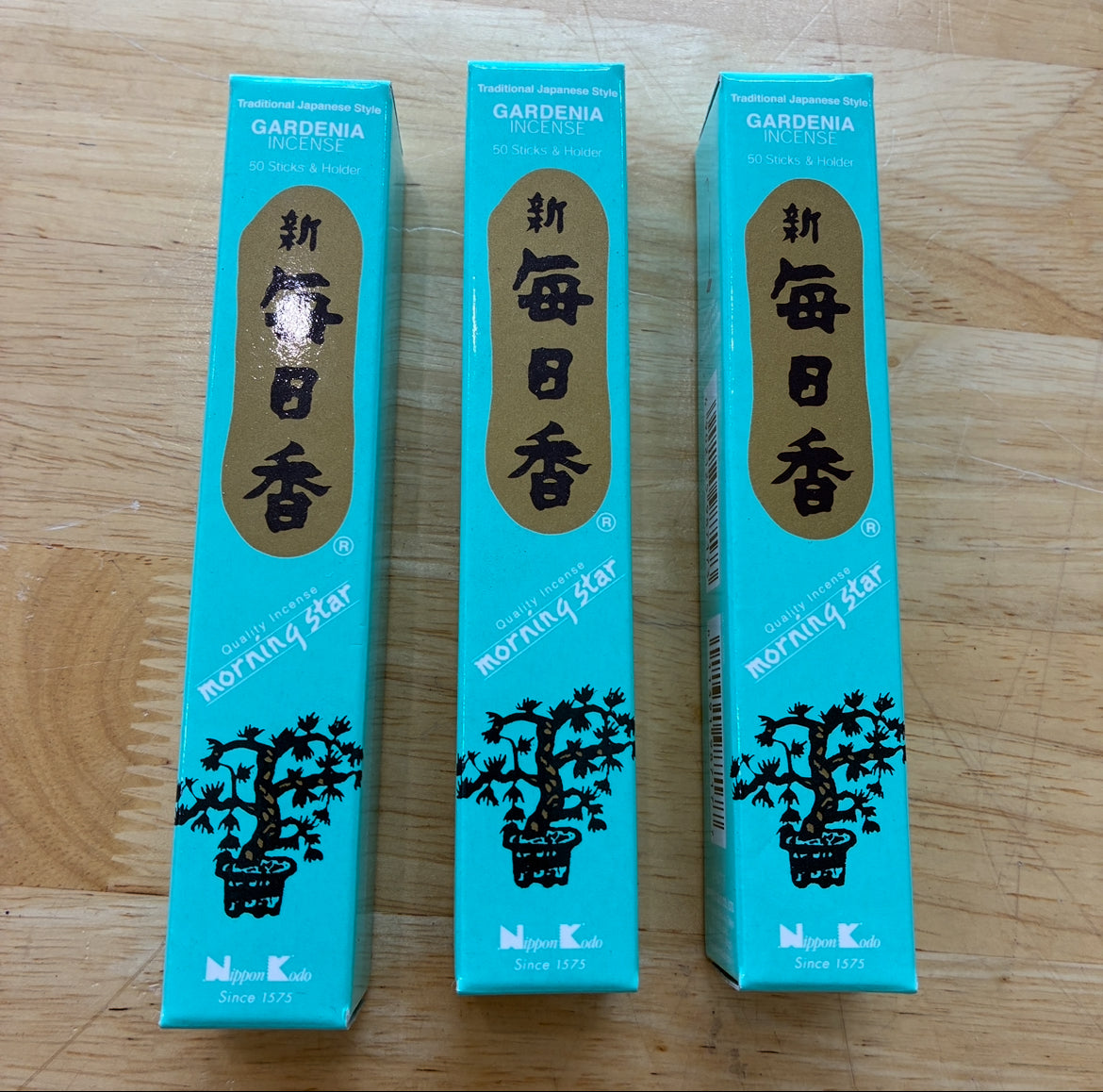 Three boxes of Morning Star Gardenia arranged side-by-side on a light-colored wooden surface.