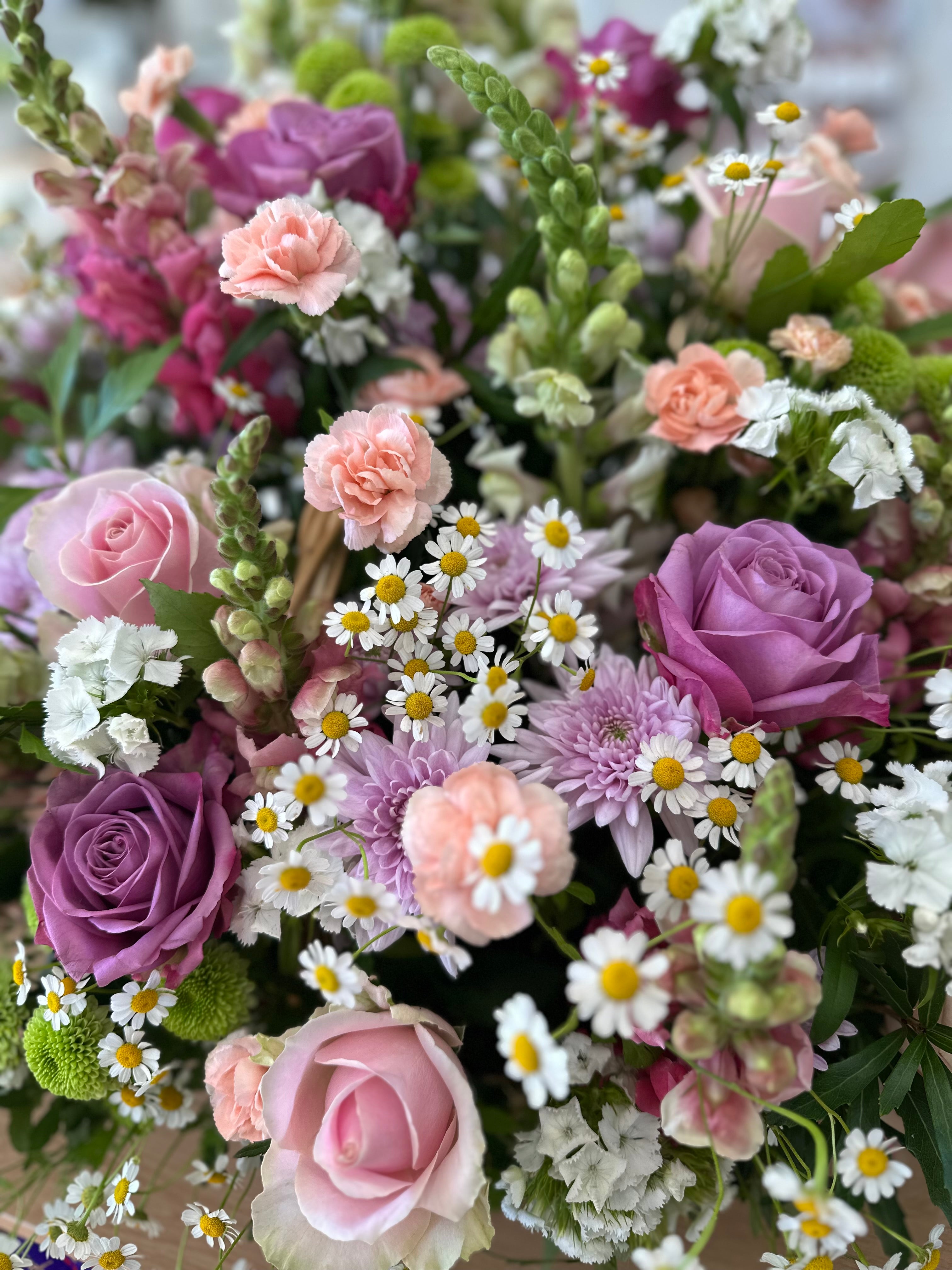 Bouquet of colorful flowers including roses and daisies.