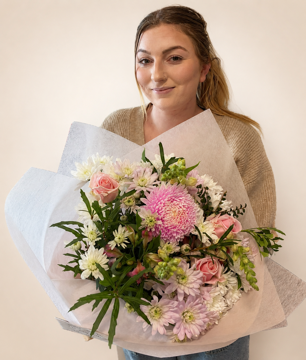 Woman holding a bouquet of flowers against a plain background at My Florist Launceston