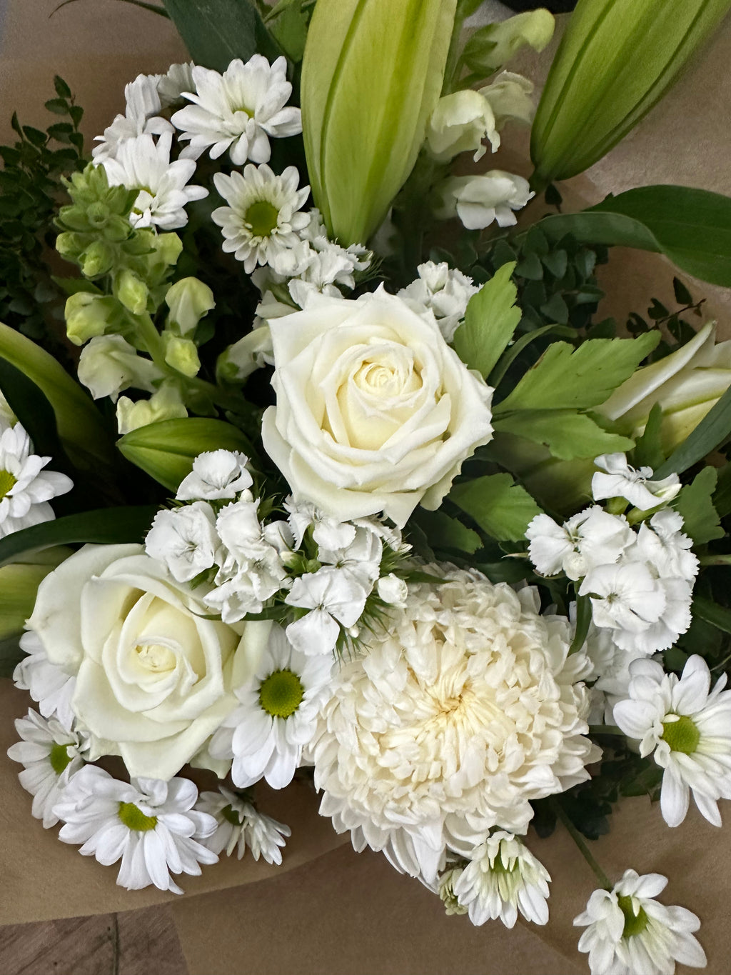 White seasonal sympathy flowers including white roses by My Florist Launceston