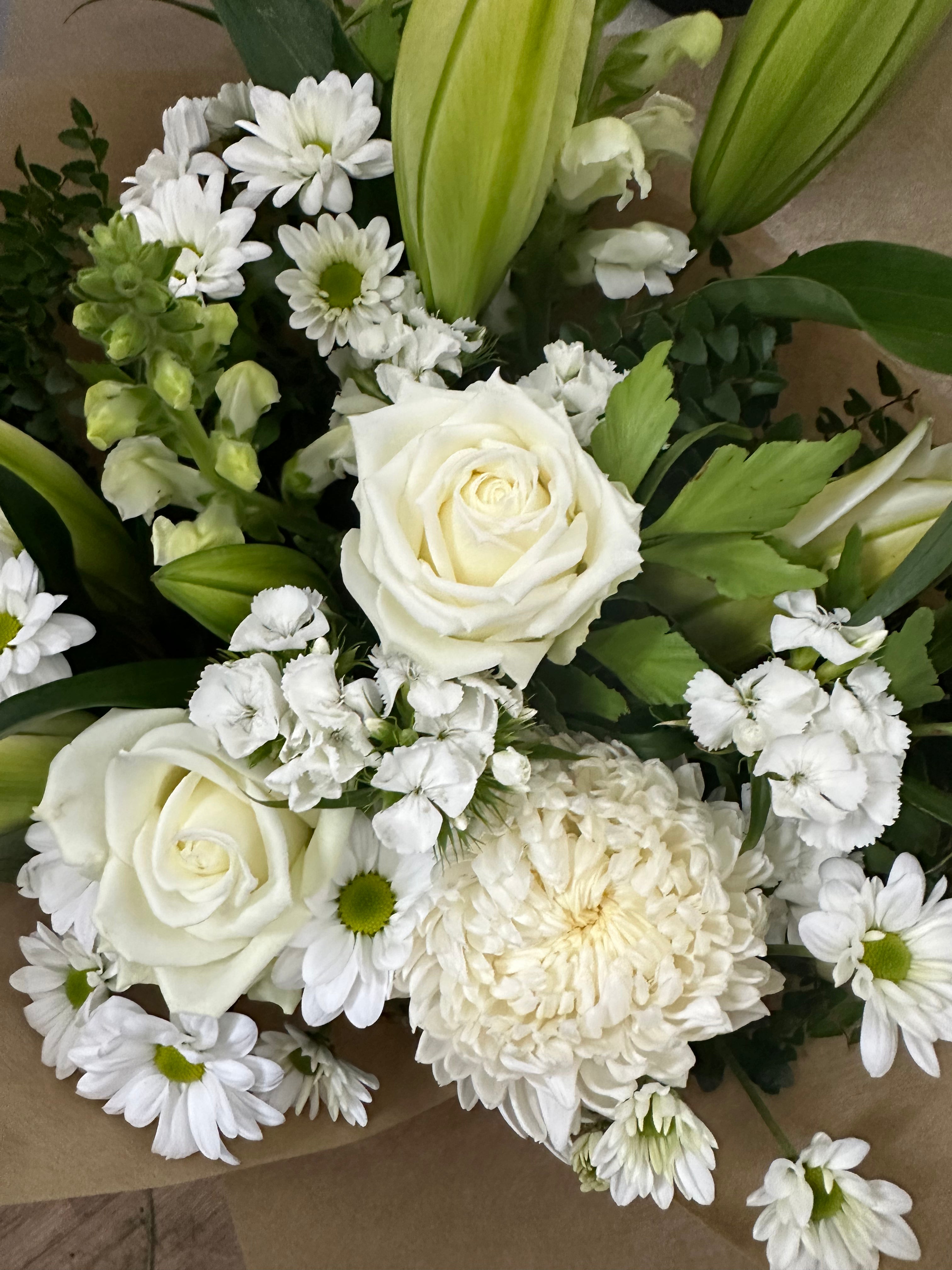 White seasonal sympathy flowers including white roses by My Florist Launceston