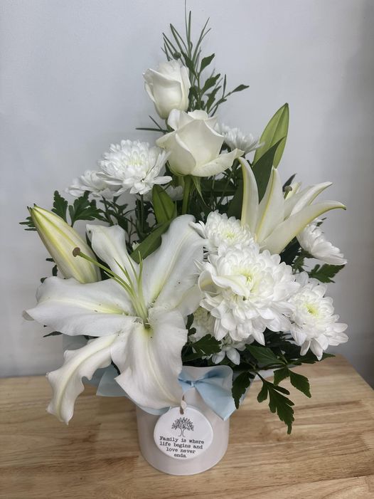 Flowers arranged in a ceramic pot with embossed ceramic quote