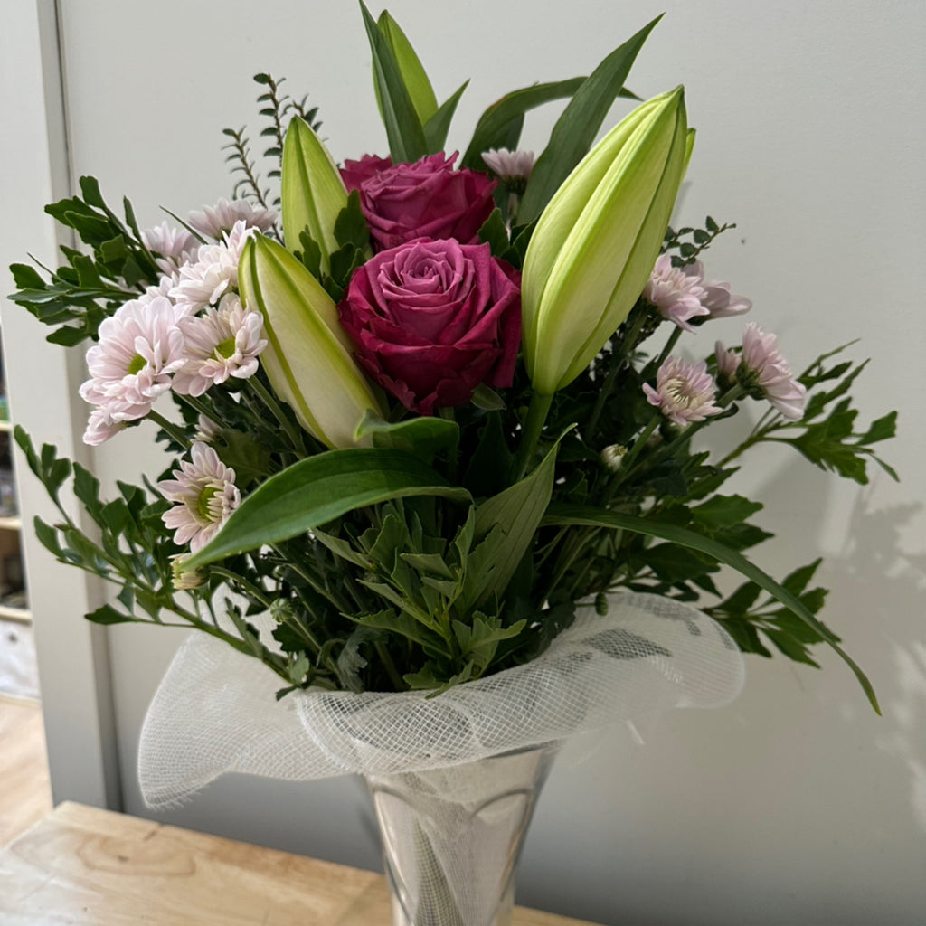 side view of flowers in a heart glass vase