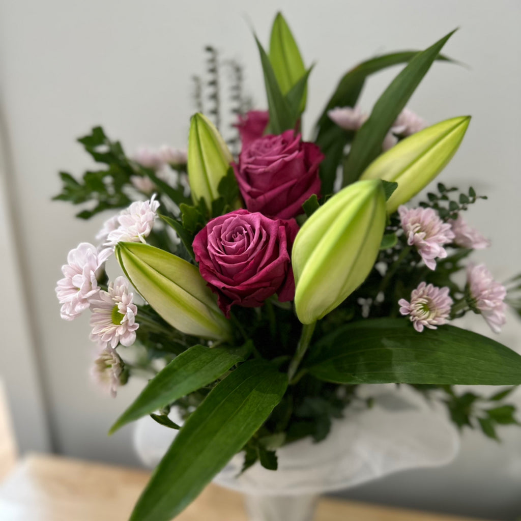 Roses, lilies and chrysanthums presented in glass vase