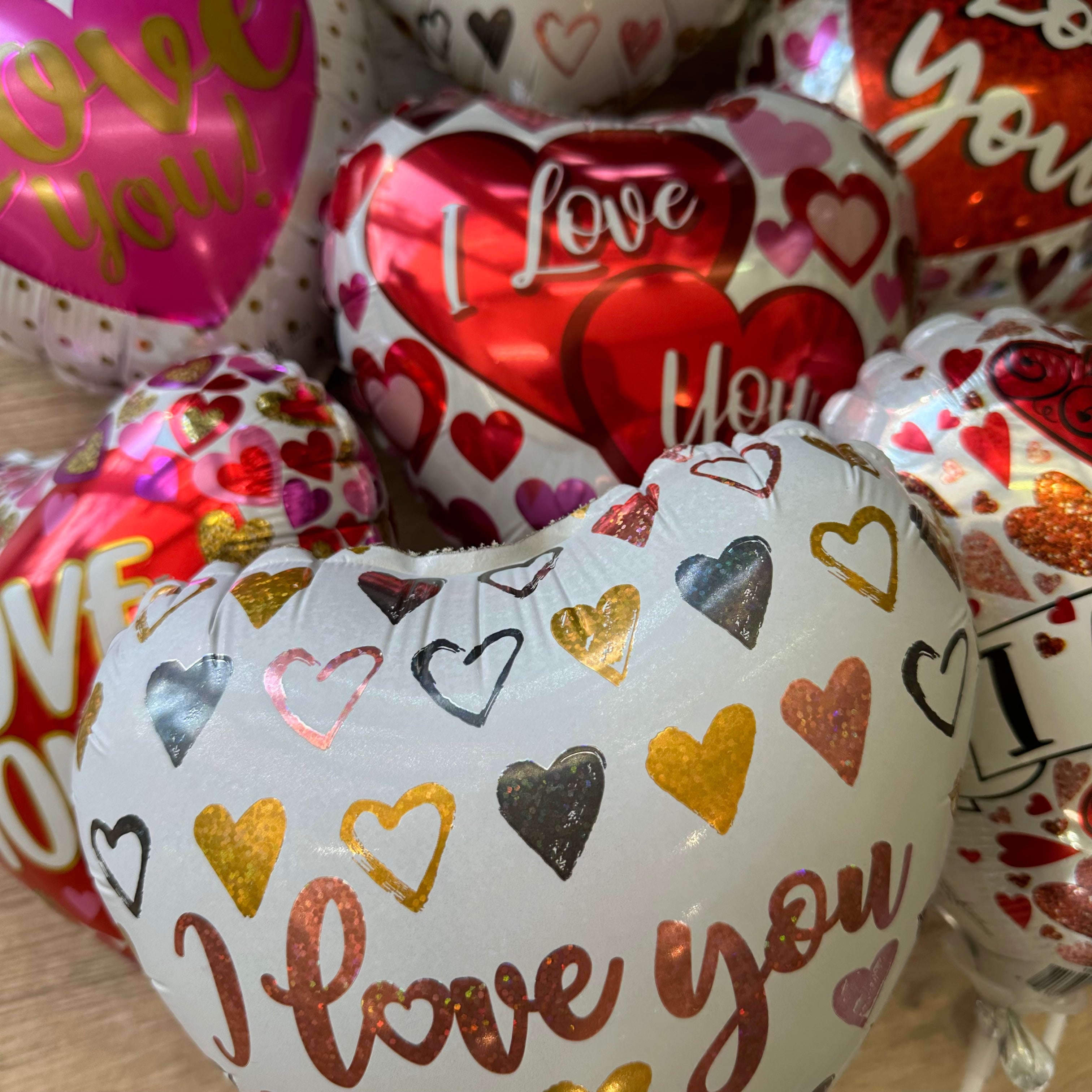 Heart-shaped balloons with 'I Love You' text and heart patterns